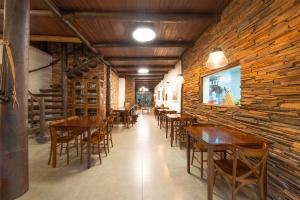 a row of tables and chairs in a restaurant at Aires de Patagonia in Cambara do Sul