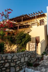 a house with a stone wall in front of it at Kiki&Nina in Halki