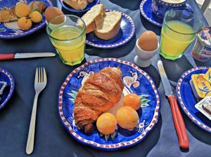 a table topped with plates of food with eggs and bread at B&B La Danza del Mare in Anacapri