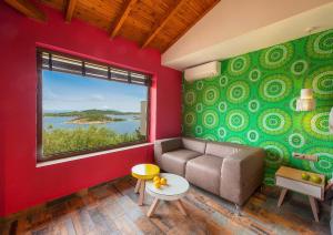 a living room with a couch and a large window at Thalassokipos in Vourvourou