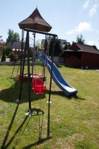 a playground with a slide in a yard at Pokoje Goscinne Anna Maria in Jastrzębia Góra