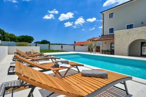 a pool with a bunch of chairs and a swimming pool at Villa Vitassi in Pula