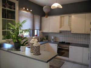 a kitchen with white cabinets and a granite counter top at Rosy's House in Chania