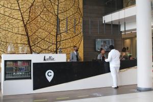 a man standing at the counter of a restaurant at Furnished, 1-bedroom, luxury apartment in Menlyn Maine in Pretoria +22 photos