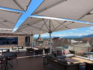 een patio met tafels, stoelen en parasols bij Best Western Plus Hotel Bern in Bern