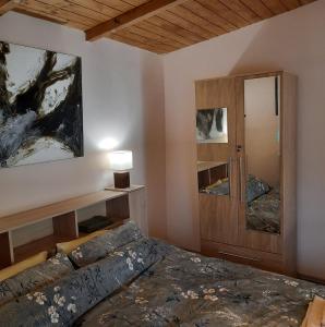 a bedroom with a bed and a wooden cabinet at Relax time Vidéken in Kiskunhalas