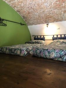 twee bedden in een kamer met groene muren bij La Petit Maison Elena in Sanremo