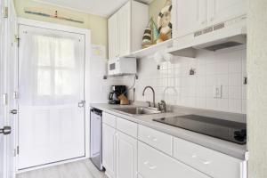 una cocina con armarios blancos y fregadero en Beach Plum Resort en Montauk