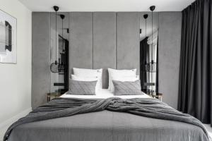 um quarto com uma cama grande com lençóis brancos e almofadas em EL Apartments - Aries em Poznań