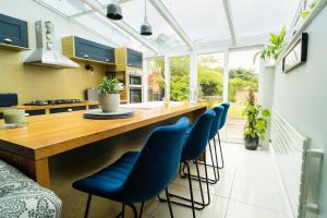 a kitchen with a large wooden table and blue chairs at You're Epic in Wimborne Minster