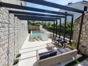 a patio with a couch and a pool at Apartments Skandi1 in Malinska