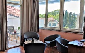 a room with chairs and tables and large windows at Blue Stella Luxury Apartment in Split