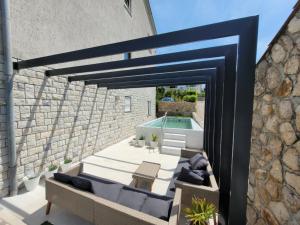 a patio with a blue couch and a pool at Apartments Skandi1 in Malinska