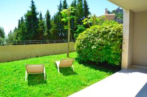 two chairs sitting in the grass in a yard at La Perle d'Eze - Aparthotel in Éze
