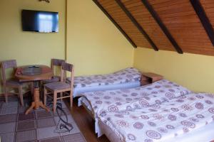 a room with two beds and a table and a tv at Pokoje Goscinne Anna Maria in Jastrzębia Góra