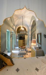 a bedroom with a bed and a room with a fireplace at Dar Antonia in Sousse