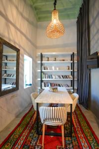 a dining room with a table and chairs and a mirror at Dar Antonia in Sousse