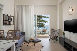 Kolymbari Sea Front Cozy Apartments في كوليمفاري: غرفة معيشة مع أريكة وتلفزيون