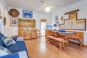 a living room with a blue couch and a table at Scopello Flat with Panoramic Courtyard and Parking in Scopello