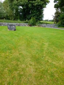 ein Park mit einer Bank auf einem Grasfeld in der Unterkunft Katy Kellys Countryside Self Catering Cottage in Roscommon