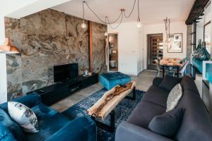 a living room with a blue couch and a stone wall at Bascarsija's Sights in Sarajevo
