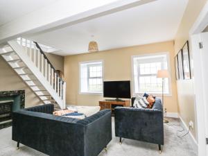 a living room with two couches and a tv at Ailsa Shores in Turnberry