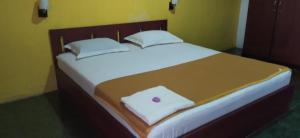 Un pat sau paturi într-o cameră la OYO 90490 Hotel Nyi Rindang
