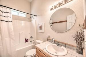 een witte badkamer met een wastafel en een spiegel bij Charming Cloudcroft Cabin with Deck and Mtn Views in Cloudcroft +17 foto's