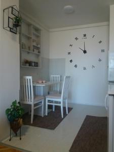 a room with two chairs and a clock on the wall at Apartman Breza in Ruma