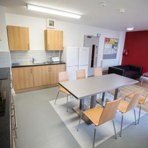 cocina y comedor con mesa y sillas en Fferm Penglais Apartments en Aberystwyth