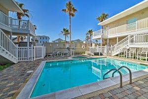 a pool in front of a building with palm trees at Modern Island Condo with Pool Steps to the Beach! in South Padre Island