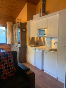 cocina con armarios blancos y microondas en PANORAMIC - Peu del Riu 502 - Vall d'Incles - Soldeu, en Incles
