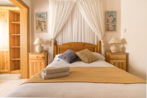 Un dormitorio con una cama grande con dos mesitas de noche. en Lantern Guest House, en Marsalforn