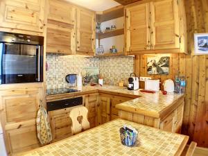a kitchen with wooden cabinets and a counter top at Ladybird Inn in Chamonix-Mont-Blanc