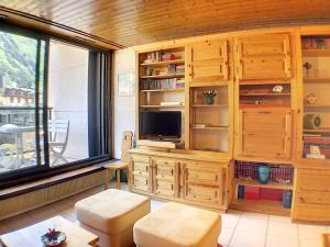 a living room with a tv and a large window at Ladybird Inn in Chamonix-Mont-Blanc