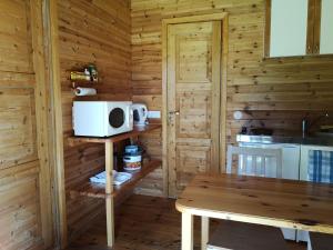 a kitchen with a table and a microwave at Tika Farmstay in Kõrkvere