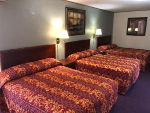 a hotel room with two beds and two lamps at Budget Host Inn - Emporia in Emporia