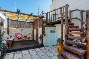 eine Terrasse mit Holztreppe und einem Tisch in der Unterkunft CIVETTHOUSE : la casa delle civette in Polignano a Mare