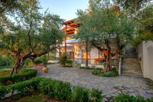a house with trees and stairs leading up to it at Panagea Holiday Apartments in Kitriaí