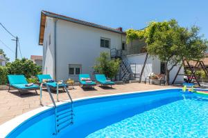 una piscina con sillas y una casa en Villa Perfect Choice just 4 U, en Kaštela