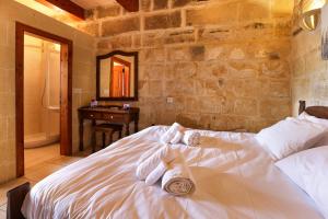 a bedroom with a bed with towels on it at Superb Maltese Farmhouse with Private Pool in Victoria