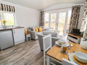 a kitchen and living room with a table and a couch at Dove Lodge in Beaworthy