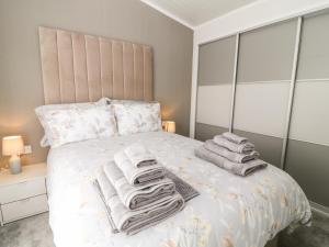a bedroom with a bed with towels on it at Dove Lodge in Beaworthy