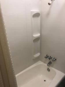 a white bathroom with a sink and a shower at Budget Host Inn - Emporia in Emporia