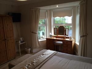 una camera con letto, specchio e cassettiera di Barr's Guest Accommodation a Moville