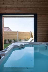 a swimming pool in a house with a large window at Au Coeur Du Village in Saint-Aubin