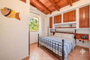 1 dormitorio con cama y ventana en Residenza Ormos - Dimore sul mare en Lampedusa