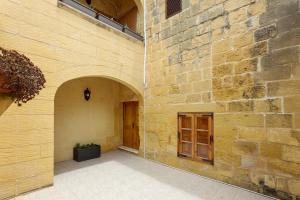 a stone building with a door and a brick wall at Superb Maltese Farmhouse with Private Pool in Victoria