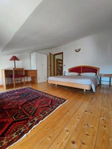 una camera con un letto e un tappeto su un pavimento in legno di un PO sul Delta ad Ariano nel Polesine