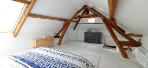 Schlafzimmer mit einem Bett in einem Zimmer mit Holzbalken in der Unterkunft Maison Coeur de Ville - Spacieuse avec Terrasse in Déville-lès-Rouen